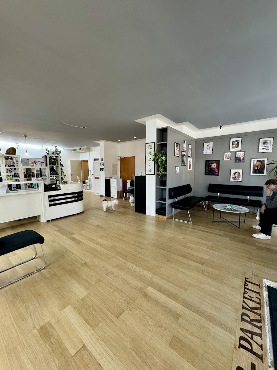 Wartebereich im Atri Salon mit Bilderwand aus Frisuren